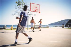 Adult Men Playing A Friendly Game Of B-Ball Outside